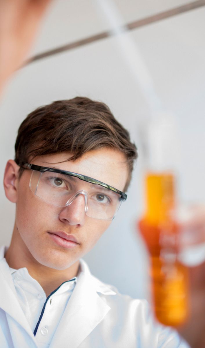 junger Mann prüft Saft Qualität im Reagenzglas