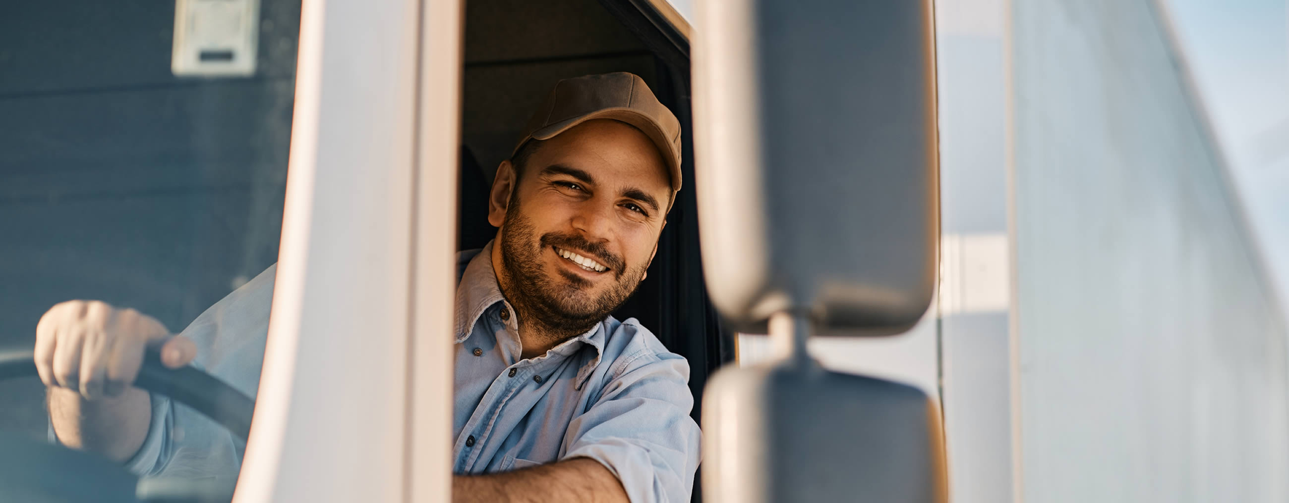 Lächelnder Mann schaut aus dem Fenster eines Lastwagen