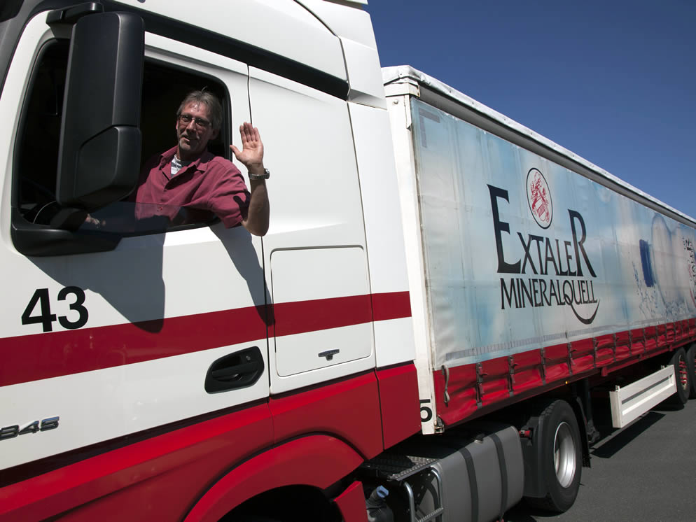 Mann schaut und winkt aus dem Fenster eines Lastwagen