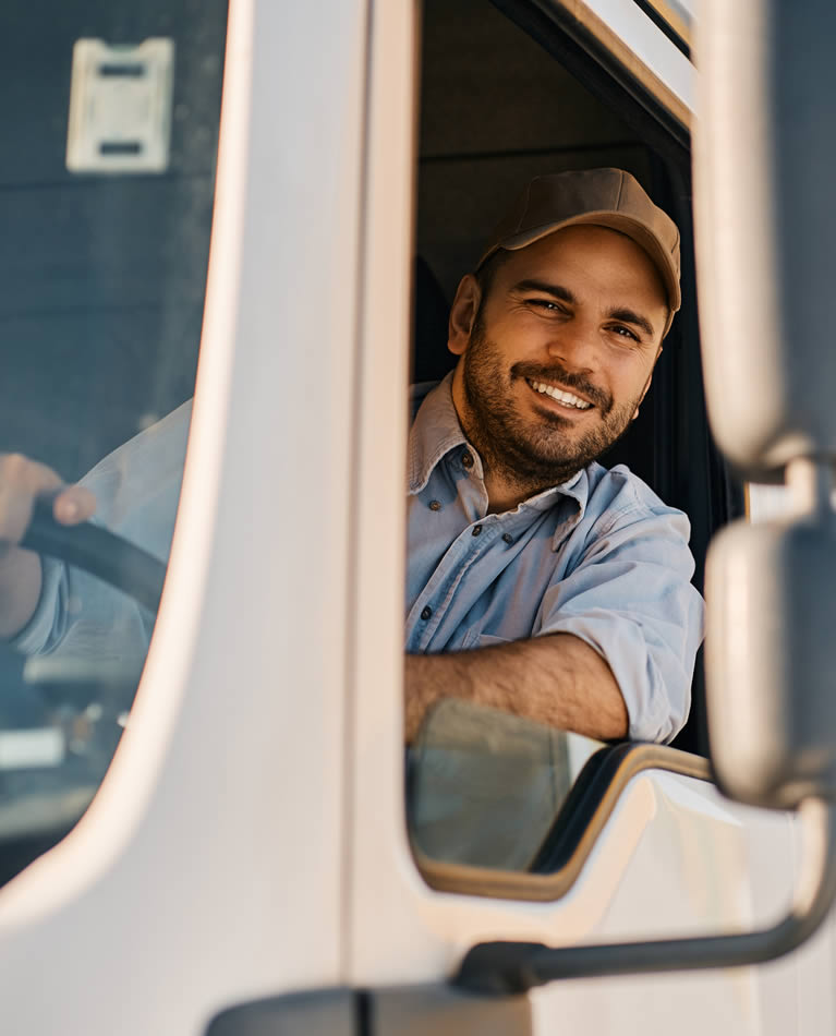 Lächelnder Mann schaut aus dem Fenster eines Lastwagen