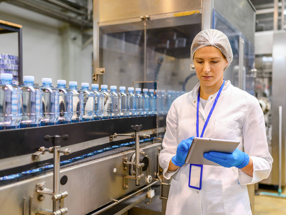 Junge Frau überwacht Prozess an der Produktionslinie