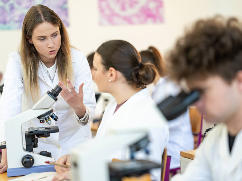 Personen in der Schule arbeiten mit Mikroskopen