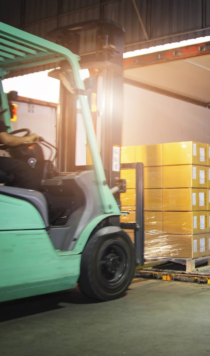 Ein Gabelstabler verladet Ware in einen Lastwagen