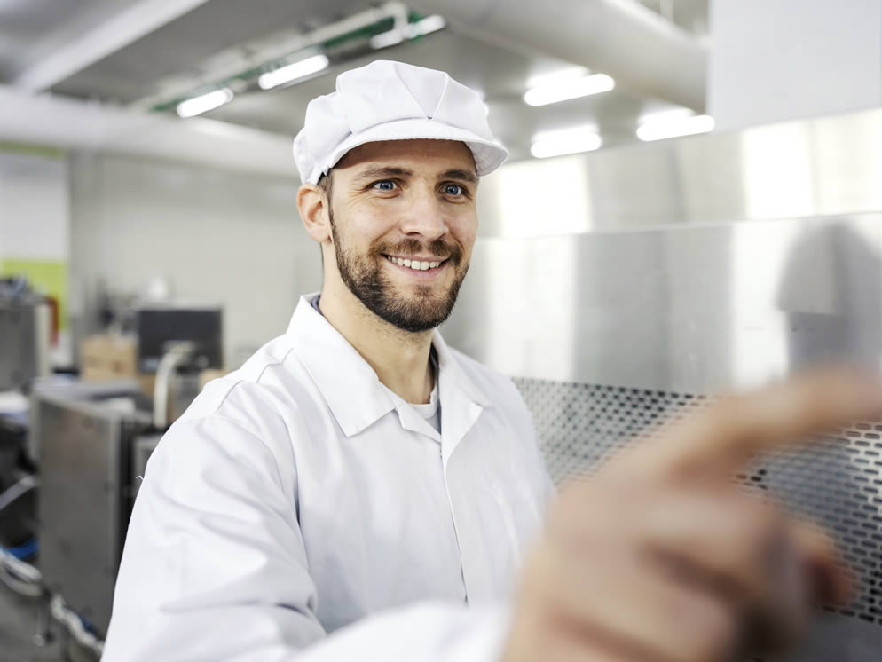 Lächelnder Mann bedient eine Maschine