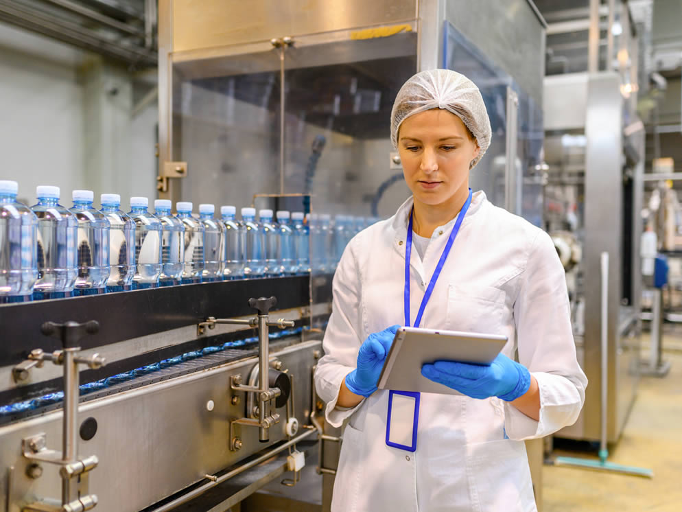 Junge Frau überwacht Prozess an der Produktionslinie
