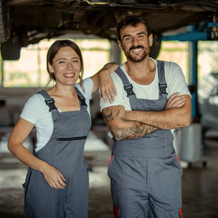 Eine junge Frau und ein Mann posieren in einer Werkstatt