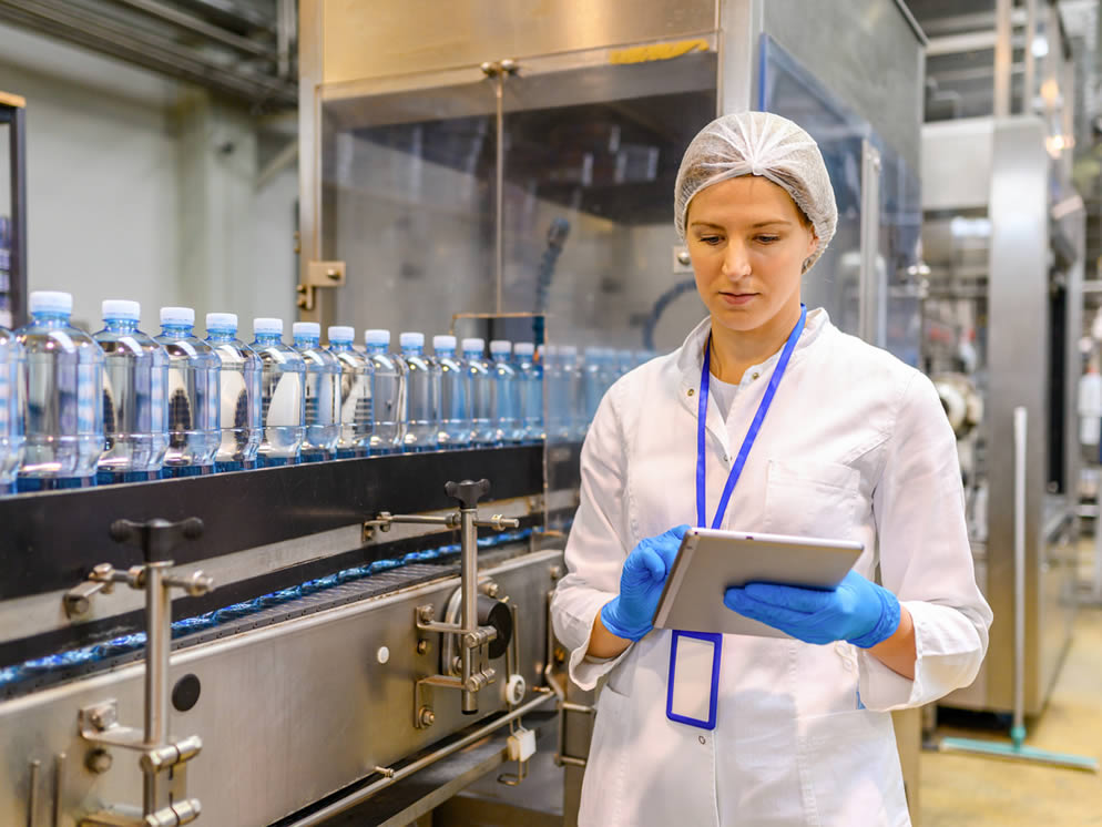 Junge Frau überwacht Prozess an der Produktionslinie