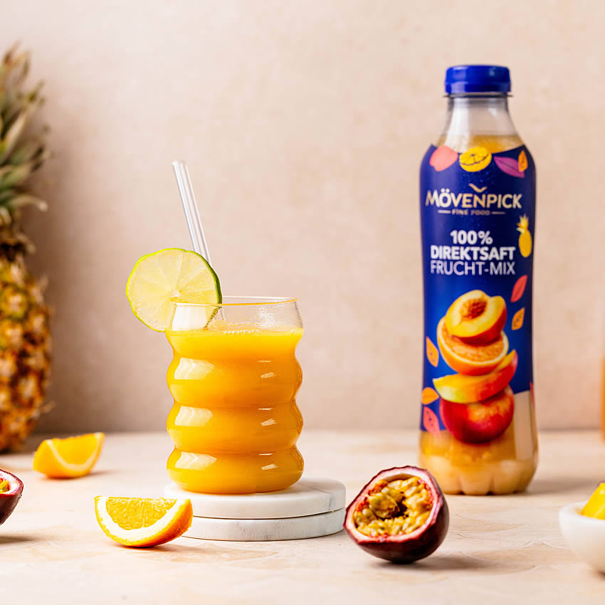 Glas gefüllt mit Mövenpick Fruchtmix, dazu Obst