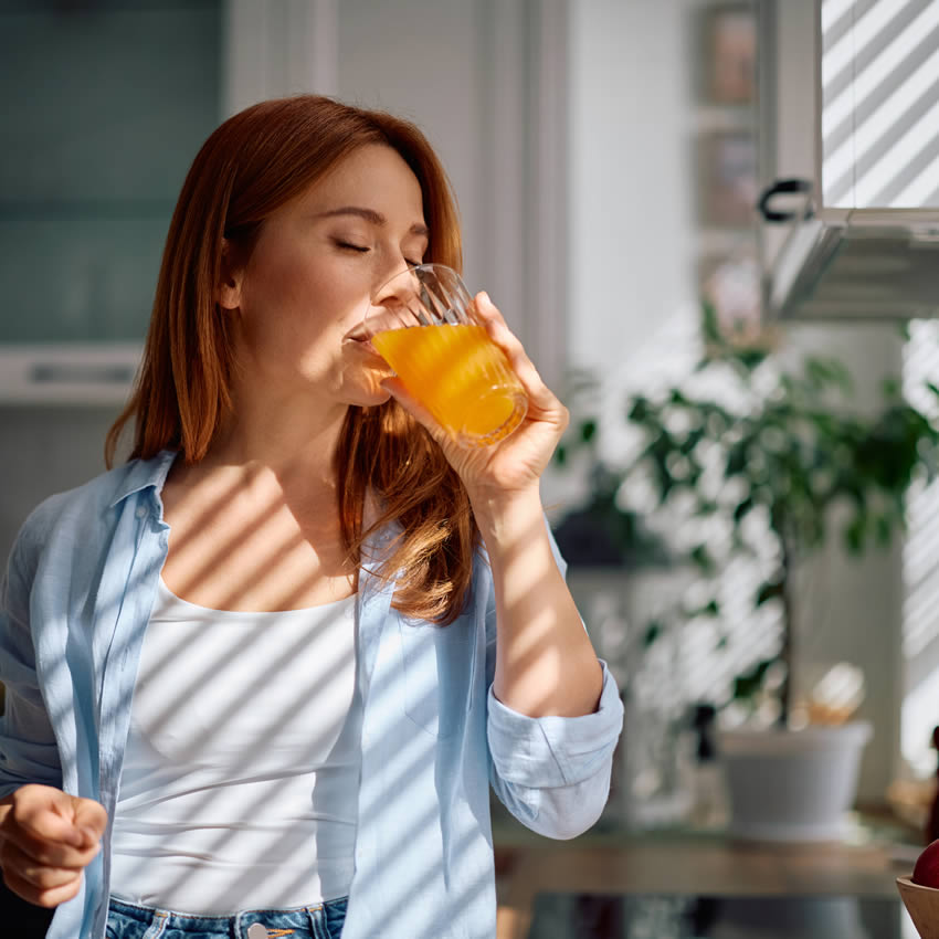 Frau trinkt naturella Orangensaft