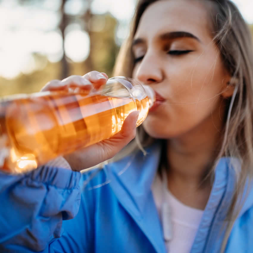 junge Frau trinkt einene EIstee