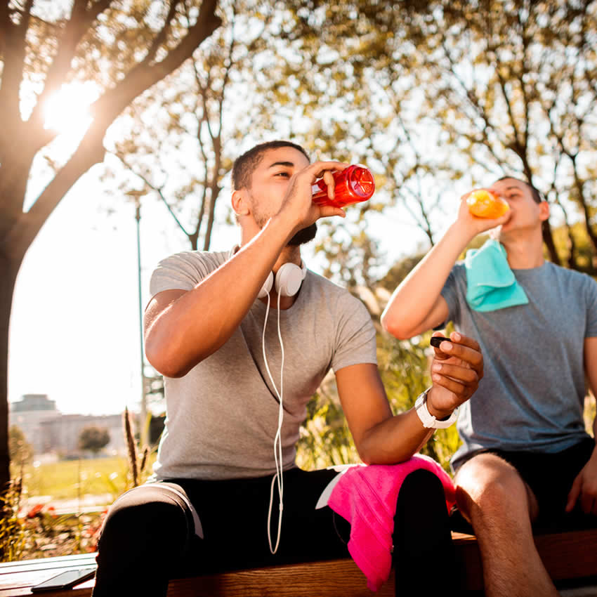 zwei Sportler trinken Quelly Sportgetränke