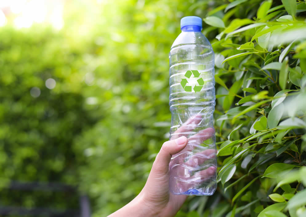 leere Flasche mit einem Recylingsymbol in der Hand