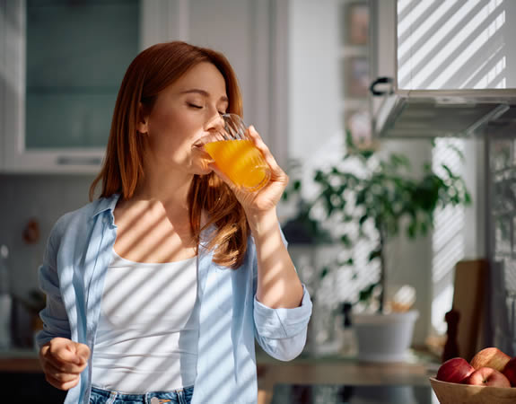 Frau trinkt Saft aus einem Glas